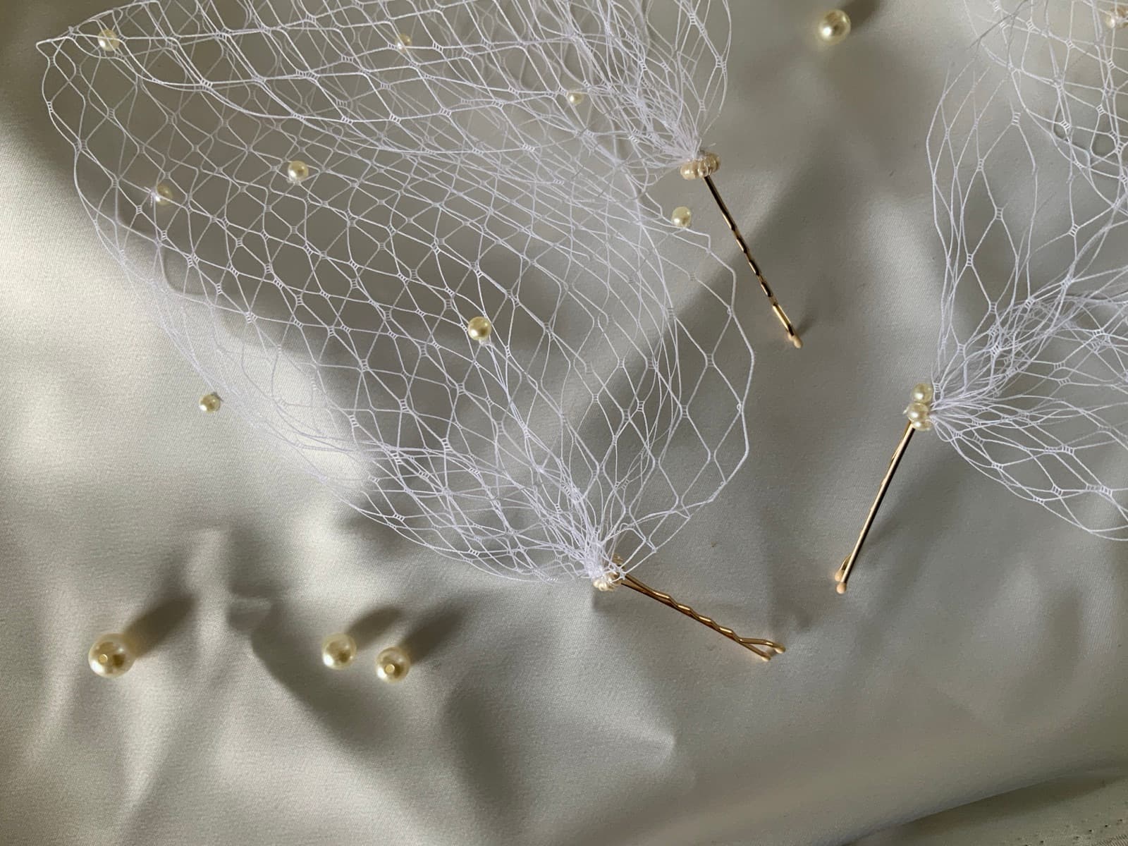 Détail de pinces dorées et de perles.